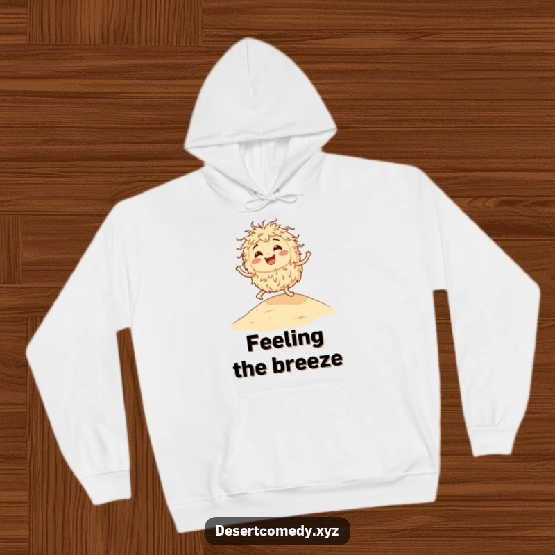 Funny hoodie depicting a happy tumbleweed casually bouncing across a vast, sunny sandy dune, radiating cheerful desert vibes.